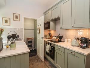 a kitchen with white cabinets and a stove top oven at No 4 Embsay in Skipton