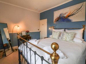 a bedroom with a large bed with blue walls at No 4 Embsay in Skipton