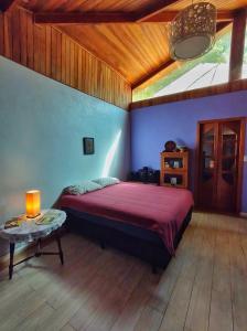 1 dormitorio con 1 cama y 1 mesa en una habitación en Casa Refúgio Cantareira en Mairiporã