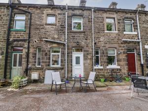 a brick building with chairs and a table in front of it at No 4 Embsay in Skipton