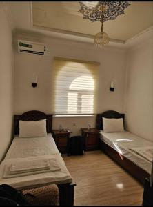 a room with two beds and a window at Khiva Khan Hotel in Khiva