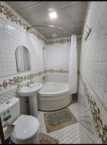 La salle de bains est pourvue de toilettes, d'un lavabo et d'une baignoire. dans l'établissement Khiva Khan Hotel, à Khiva