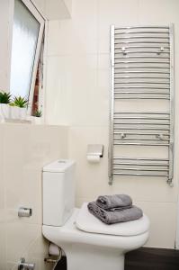 Baño con aseo y toalla en 29EW Dreams Unlimited Serviced Accommodation- Staines - Heathrow, en Stanwell