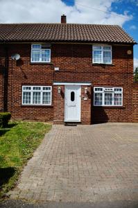 a brick house with a white door and windows at 29EW Dreams Unlimited Serviced Accommodation- Staines - Heathrow in Stanwell