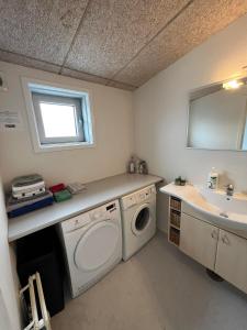 La salle de bains est pourvue d'un lave-linge et d'un lavabo. dans l'établissement Kang Apartment, à Nuuk