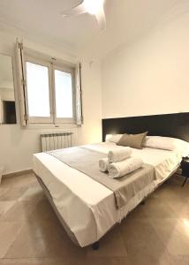 1 dormitorio con 1 cama blanca grande y toallas. en Villa rooms, en Madrid