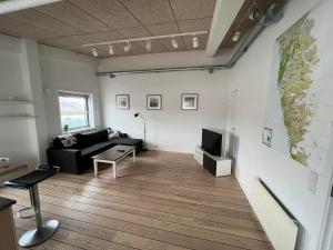 ein Wohnzimmer mit einem Sofa und einer Karte an der Wand in der Unterkunft Kang Apartment in Nuuk