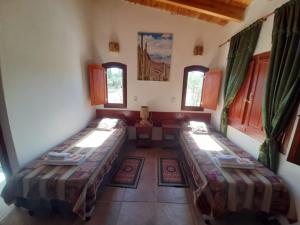 a room with two beds in a room with windows at Casa de CAMPO HUAKA HUASY in Cachí