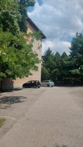 zwei Autos auf einem Parkplatz neben einem Gebäude geparkt in der Unterkunft Apartman Milica in Vršac