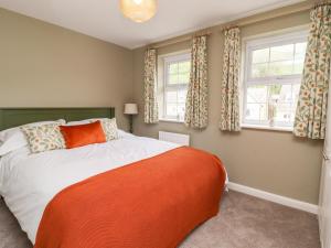 a bedroom with a bed and two windows at The Milne in Todmorden