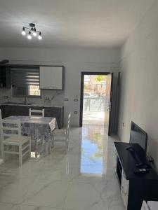 een keuken en eetkamer met een tafel en stoelen bij Taku apartment in Sarandë