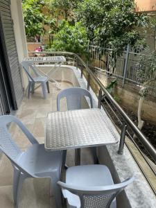 een tafel en stoelen op een balkon bij Taku apartment in Sarandë