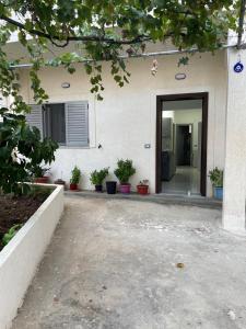 uma porta para uma casa com vasos de plantas em frente em Taku apartment em Saranda