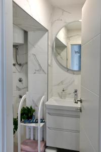 a white bathroom with a sink and a mirror at Golden Neretva apartments in Metković