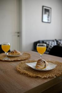 a table with two glasses of orange juice and croissants at Golden Neretva apartments in Metković