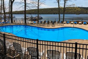 a large blue swimming pool with chairs and a lake at 6 Fieldstone Ct in Lake Harmony