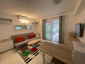 a living room with a couch and a table at Lujoso apartamento Oasis con piscina a 50 metros de la playa y pueblo de Denia in Denia