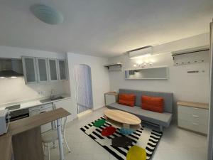 a small living room with a couch and a table at Lujoso apartamento Oasis con piscina a 50 metros de la playa y pueblo de Denia in Denia