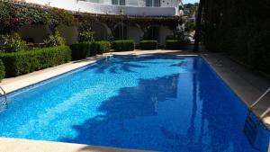 a swimming pool with blue water in a building at Lujoso apartamento Oasis con piscina a 50 metros de la playa y pueblo de Denia in Denia