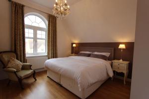 - une chambre avec un lit, une chaise et un lustre dans l'établissement Immaculate 4BD Family Home in Lee on the Solent, à Lee-on-the-Solent