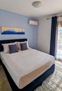 een slaapkamer met een groot bed met blauwe muren bij Casa Christiana, Lardos in Lardos