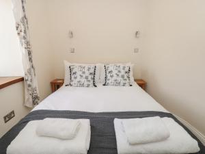 a bedroom with a bed with white sheets and pillows at Spanish Boathouse in Brixham