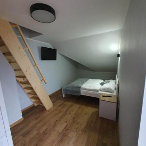niewielka sypialnia z łóżkiem i schodami w obiekcie Agroturystyka Koronkowe Zacisze w mieście Koniaków