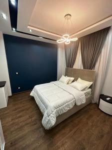 um quarto com uma cama grande e uma parede azul em Cozy Elite One Bedroom Apartment em Sheikh Zayed