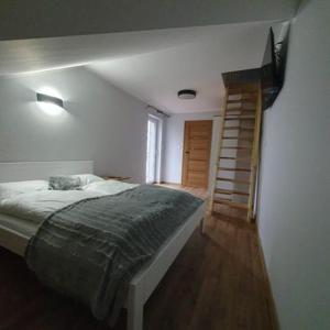 a bedroom with a bed and a staircase in it at Agroturystyka Koronkowe Zacisze in Koniaków