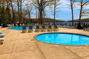 a swimming pool with chairs and a table and water at Midlake Memories in Lake Harmony
