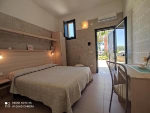 Habitación de hotel con cama, mesa y ventana en Masseria Don Egidio, en Melendugno
