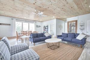 una sala de estar con sofás azules y una mesa. en Muskoka Getaway-Trails/Hot Tub/Hike/Fish/Ski/Relax, en Honey Harbor