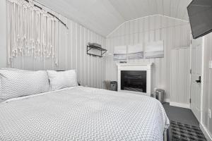 Dormitorio blanco con cama y chimenea en Muskoka Getaway-Trails/Hot Tub/Hike/Fish/Ski/Relax, en Honey Harbor