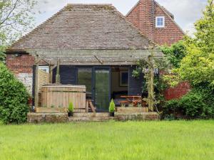 a small house with a patio and a table at The Snug at Pickelden Farmhouse in Canterbury