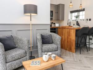 a living room with two chairs and a table at The Snug at Pickelden Farmhouse in Canterbury