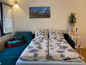 Sofá azul en la sala de estar con manta en Höri Nest - Wohlfühl Appartement, en Gaienhofen