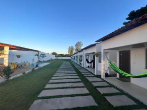 a walkway between two buildings with green grass at Pousada Mangaba in Barreirinhas