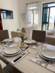 a wooden table with plates and a plant on it at Monolocale Nonna Ita in Santa Teresa Gallura