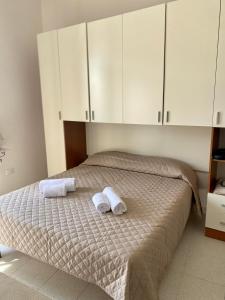 a bedroom with a bed with two towels on it at Monolocale Nonna Ita in Santa Teresa Gallura