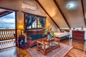 ein Schlafzimmer mit einem Bett, einer Couch und einem Tisch in der Unterkunft Hotel Bocas del Toro in Bocas del Toro