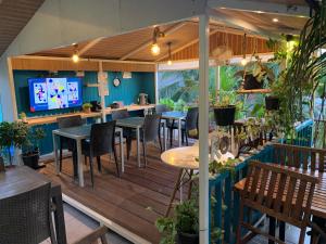 ein Restaurant mit Tischen und Stühlen sowie einem TV in der Unterkunft Koimala Hotel in Maamigili