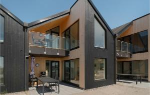 een zwart huis met een balkon en een tafel bij Kysthus 27 in Engvang