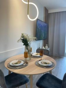 a dining room table with four chairs and a dining room at Apartament Kameralis Old Town - klimatyzacja - balkon - winda in Elblag