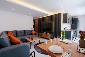 Mrt Suites Lara في أنطاليا: غرفة معيشة مع أريكة وطاولة