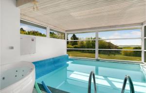 a swimming pool in a house with a tub and windows at Stunning Home In Knebel With Sauna, Wifi And Indoor Swimming Pool in Knebel