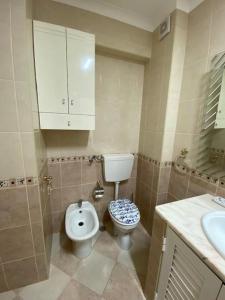 een kleine badkamer met een toilet en een wastafel bij Apartamento Girassol in Luz