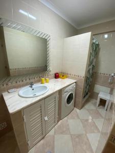 een badkamer met een wastafel en een wasmachine bij Apartamento Girassol in Luz