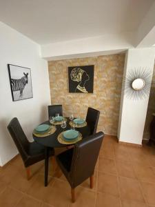 een eetkamer met een zwarte tafel en stoelen bij Apartamento Girassol in Luz