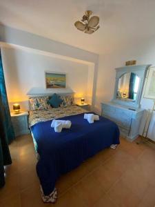een slaapkamer met een blauw bed en 2 nachtkastjes bij Apartamento Girassol in Luz