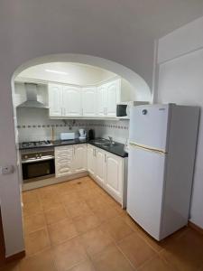 een keuken met witte kasten en een witte koelkast bij Apartamento Girassol in Luz